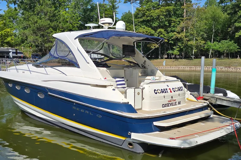  Yacht Photos Pics 2003 Regal Commodore 4260 yacht docked in a serene marina setting.