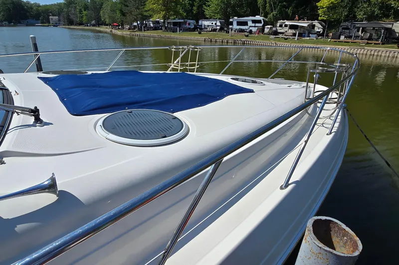  Yacht Photos Pics 2003 Regal Commodore 4260 yacht docked by a serene lakeside with lush greenery.