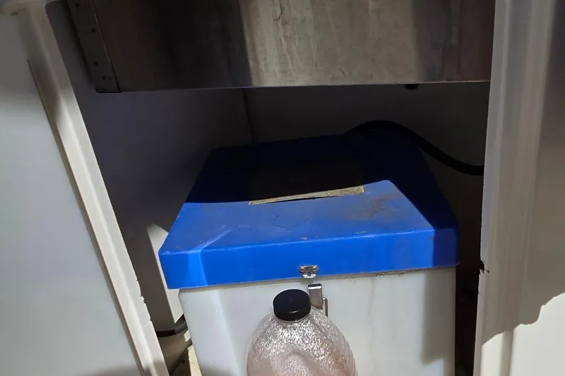  Yacht Photos Pics Storage compartment in a 2003 Regal Commodore 4260 boat, featuring a blue-lidded container.