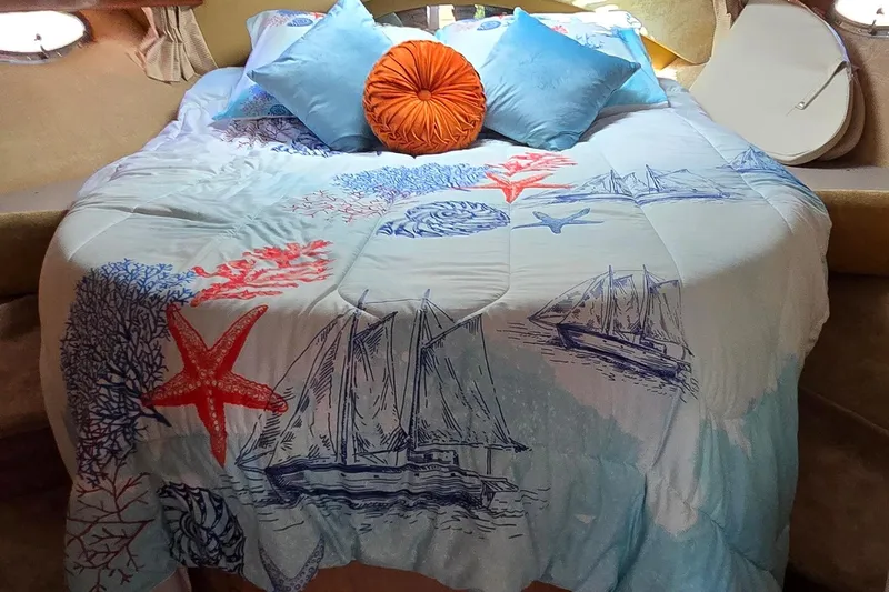  Yacht Photos Pics Cozy bed in 2003 Regal Commodore 4260 with nautical-themed bedding and colorful pillows.