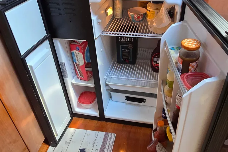  Yacht Photos Pics Refrigerator inside 2003 Regal Commodore 4260 yacht, stocked with various food items and beverages.