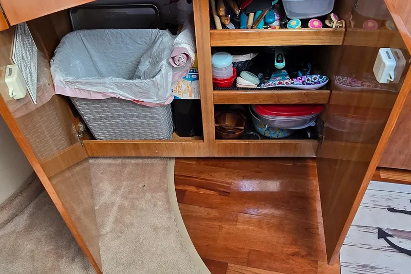  Yacht Photos Pics Open cabinet in 2003 Regal Commodore 4260, showing organized storage and trash bin.