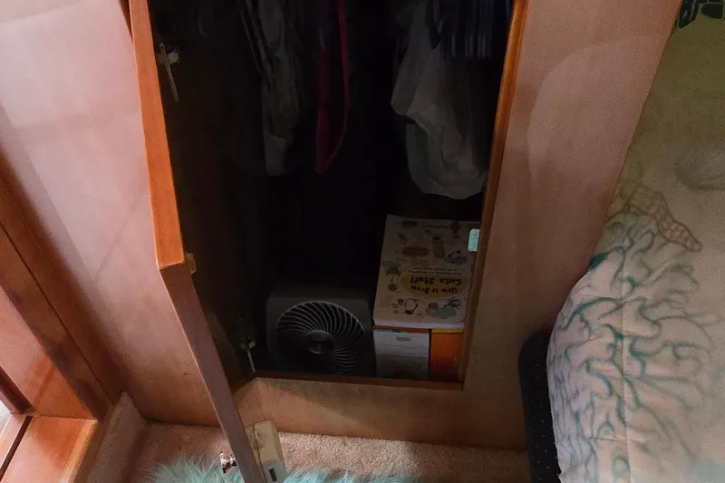  Yacht Photos Pics Open closet in 2003 Regal Commodore 4260, showing fan and box storage.