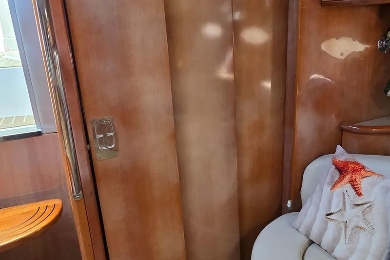  Yacht Photos Pics Interior of 2003 Regal Commodore 4260 yacht with wooden paneling and starfish-themed pillow.