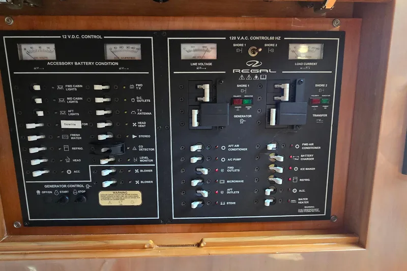  Yacht Photos Pics Control panel of a 2003 Regal Commodore 4260 boat, featuring electrical switches and gauges.