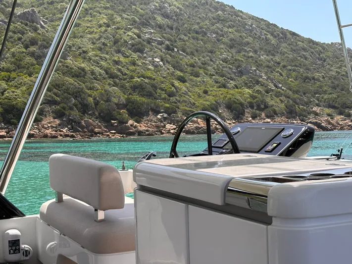 Kajikia Yacht Photos Pics Lagoon 77 yacht helm with scenic coastal view, 2023 model.