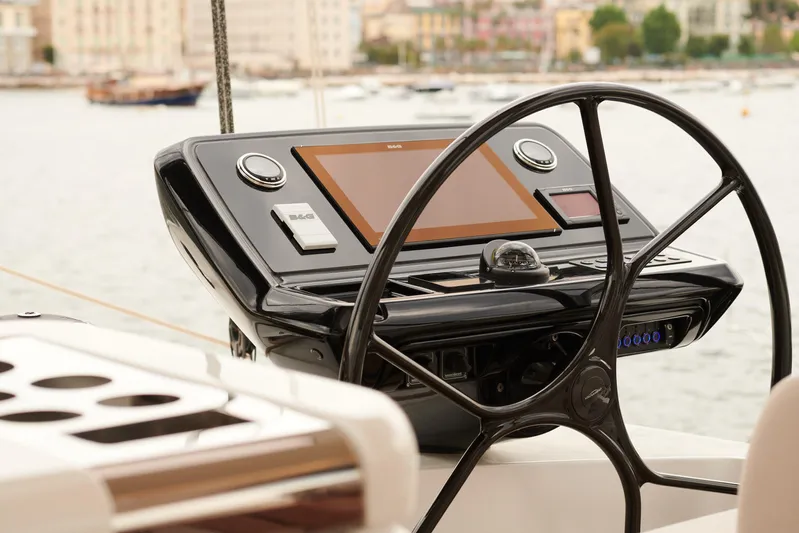 Kajikia Yacht Photos Pics Steering wheel and control panel of 2023 Lagoon 77 yacht, docked in a marina.