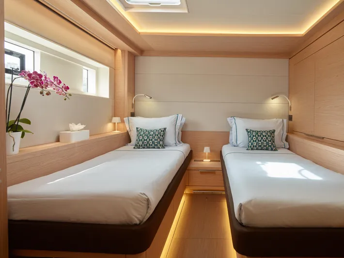 Kajikia Yacht Photos Pics Luxurious 2023 Lagoon 77 yacht cabin with twin beds, modern decor, and elegant lighting.