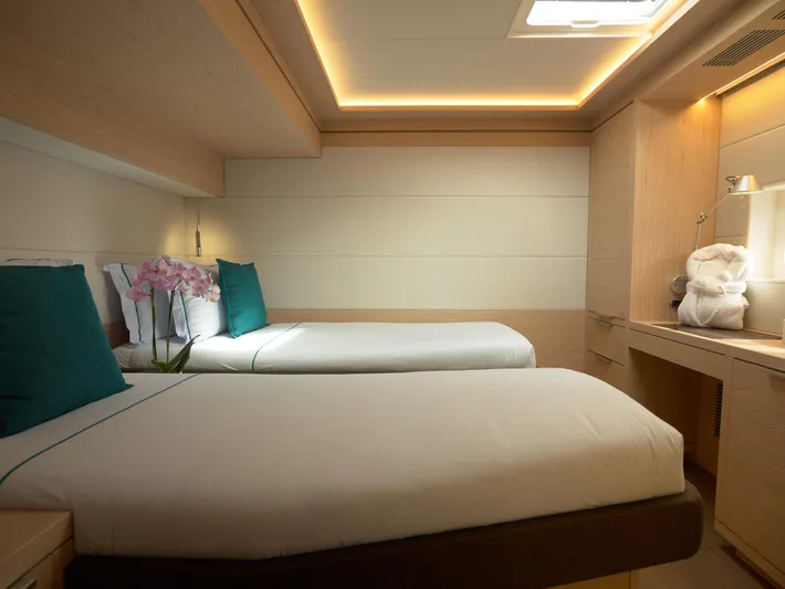 Kajikia Yacht Photos Pics Luxurious cabin interior of 2023 Lagoon 77 yacht with twin beds and elegant lighting.