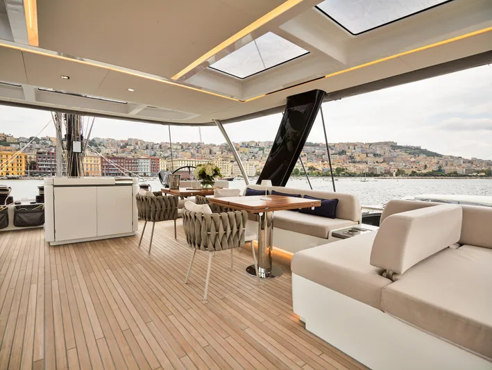 Kajikia Yacht Photos Pics Luxurious 2023 Lagoon 77 yacht deck with elegant seating and scenic waterfront view.