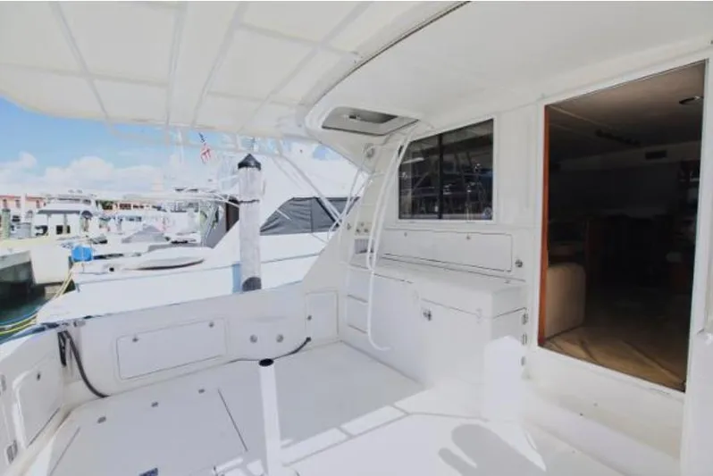  Yacht Photos Pics 2003 Riviera 48 yacht docked at marina, spacious deck area.