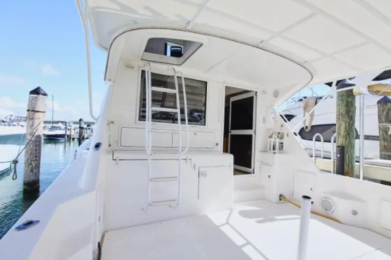  Yacht Photos Pics 2003 Riviera 48 yacht stern view with ladder and marina background.