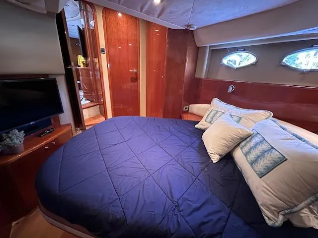 Everything 4 Sail Yacht Photos Pics Luxurious cabin interior of 2006 Princess 58v yacht with cozy bedding and elegant wood finishes.