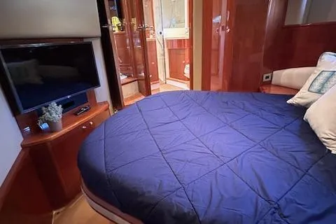 Everything 4 Sail Yacht Photos Pics Luxurious bedroom interior of 2006 Princess 58v yacht with TV and ensuite bathroom.