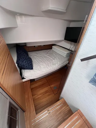  Yacht Photos Pics 2023 Tiara Yachts 38 LS cabin interior with bed, TV, and wooden flooring.