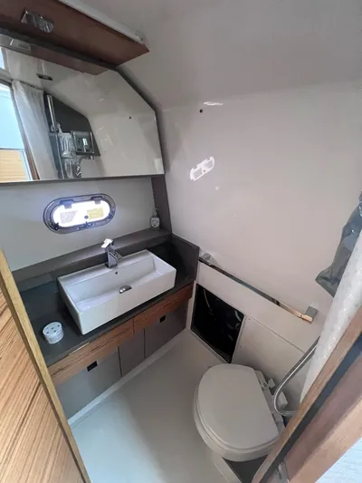  Yacht Photos Pics 2023 Tiara Yachts 38 LS bathroom with modern sink, mirror, and compact toilet.