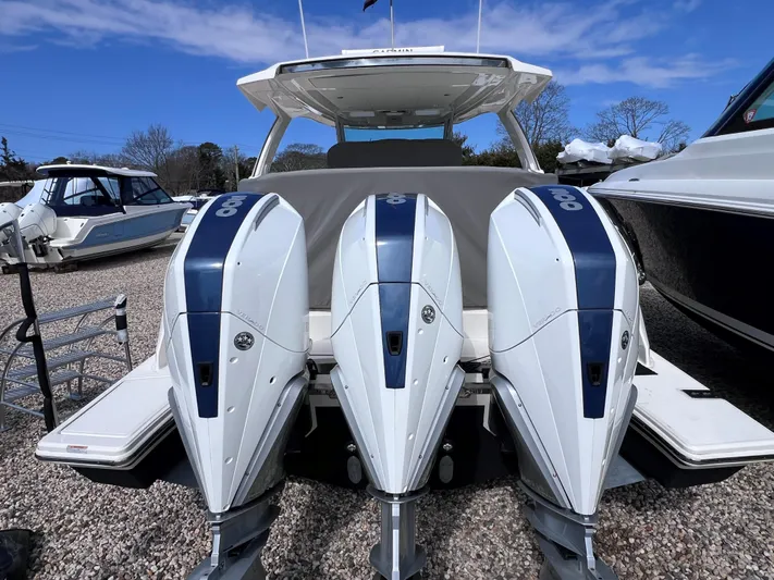  Yacht Photos Pics 2023 Tiara Yachts 38 LS with triple outboard engines, docked under a clear blue sky.