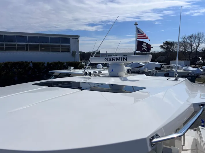  Yacht Photos Pics 2023 Tiara Yachts 38 LS with Garmin equipment and American flag, docked under clear sky.