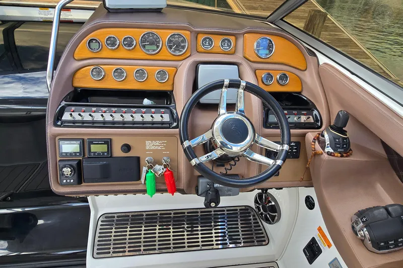  Yacht Photos Pics Dashboard of a 2011 Cobalt 323 boat with steering wheel and control panel.