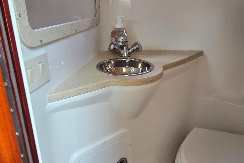  Yacht Photos Pics Compact bathroom sink in 2011 Cobalt 323 boat, featuring a stainless steel basin and faucet.