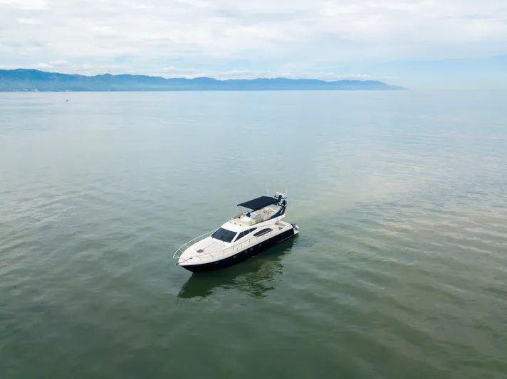 Arion Yacht Photos Pics 2003 Ferretti Yachts 530 cruising on calm waters with scenic mountain backdrop.