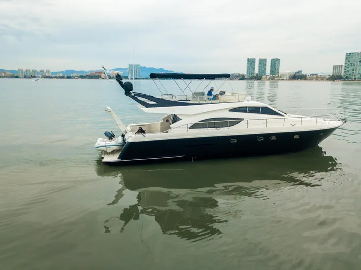 Arion Yacht Photos Pics 2003 Ferretti Yachts 530 cruising on calm waters near a city skyline.