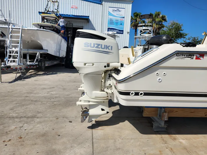 N' Pursuit Yacht Photos Pics 2005 Pursuit 3070 Offshore Center Console with Suzuki outboard motor in a boatyard.