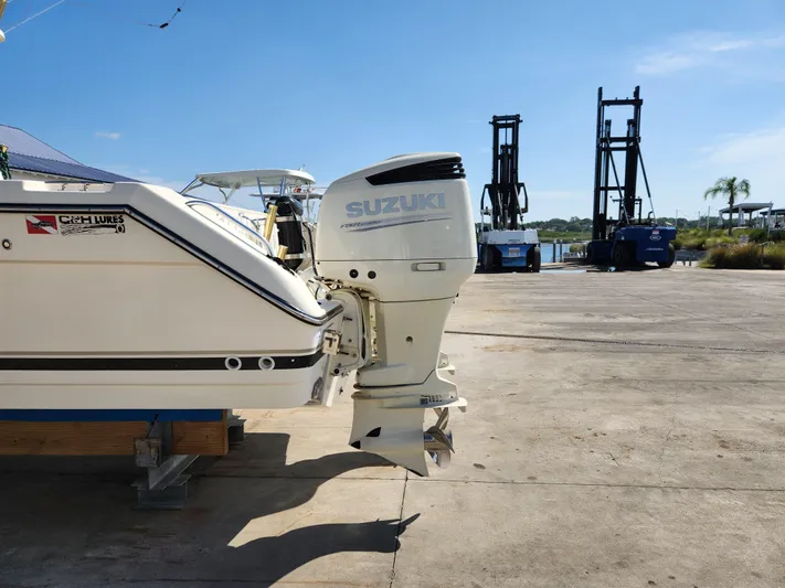 N' Pursuit Yacht Photos Pics 2005 Pursuit 3070 Offshore Center Console with Suzuki outboard motor on a sunny dock.