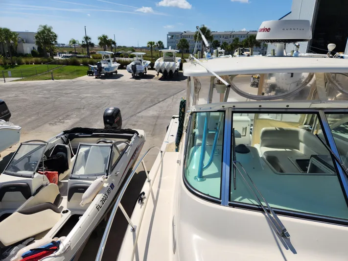 N' Pursuit Yacht Photos Pics 2005 Pursuit 3070 Offshore Center Console boat docked near other boats under a clear sky.