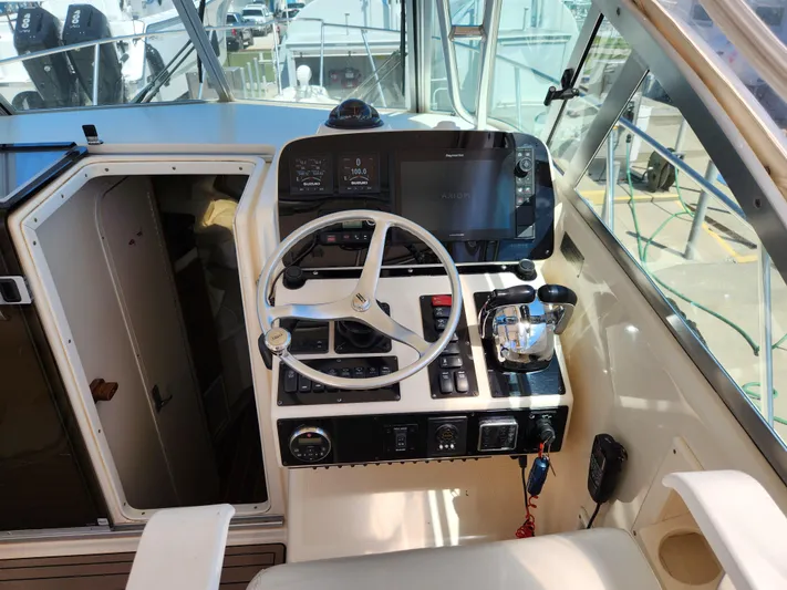 N' Pursuit Yacht Photos Pics 2005 Pursuit 3070 Offshore Center Console helm with steering wheel and navigation controls.