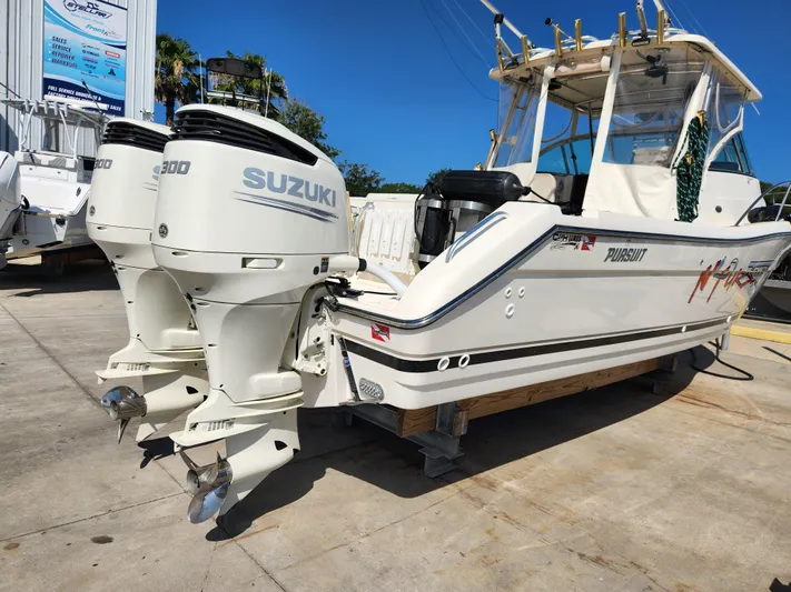 N' Pursuit Yacht Photos Pics 2005 Pursuit 3070 Offshore Center Console boat with twin Suzuki engines, docked outdoors.