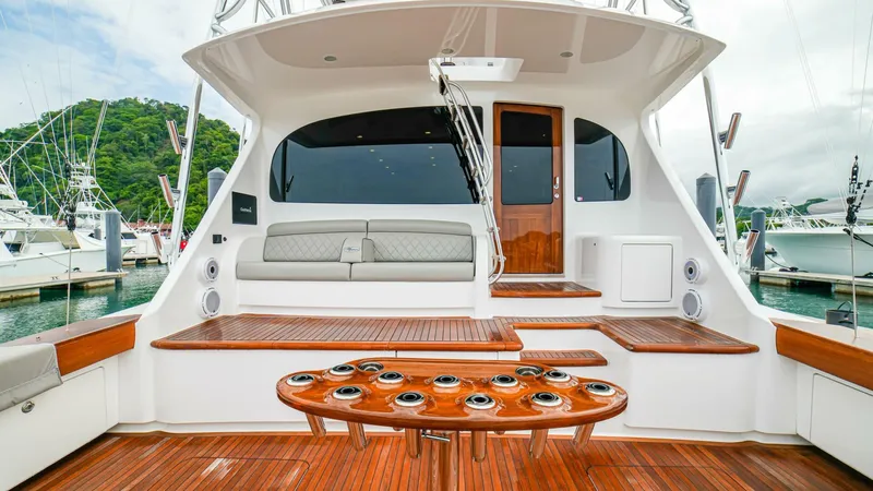 Free Spool Yacht Photos Pics 2023 Viking 72 yacht with luxurious teak deck and seating area in a marina.
