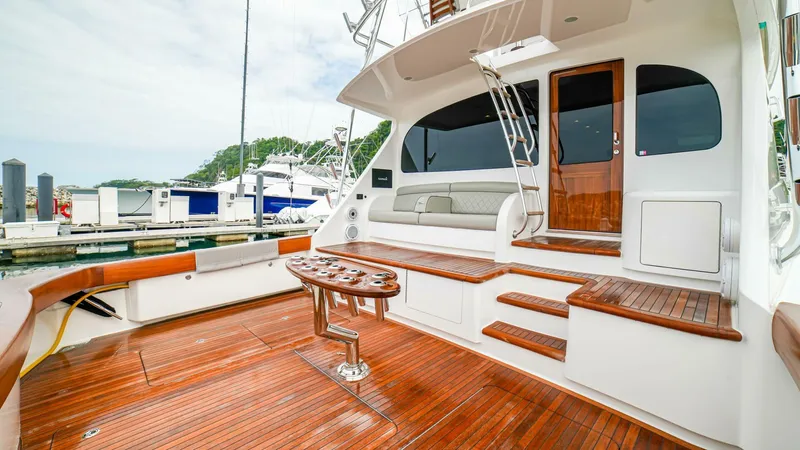 Free Spool Yacht Photos Pics Luxurious 2023 Viking 72 yacht with elegant wooden deck and seating area at marina.