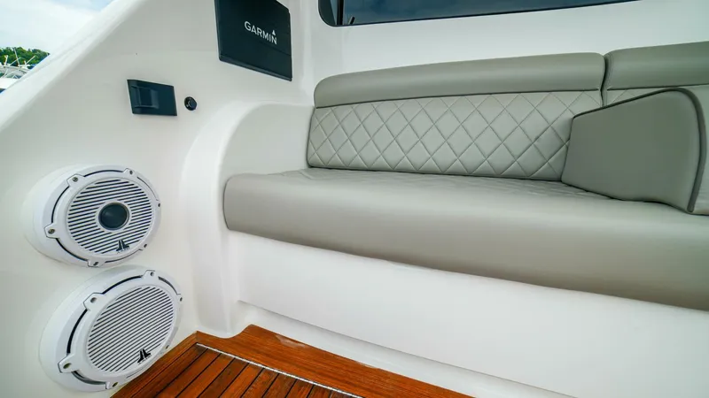 Free Spool Yacht Photos Pics Luxurious seating area on 2023 Viking 72 yacht with speakers and wood flooring.