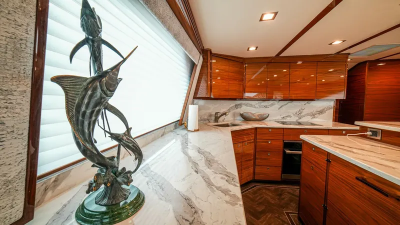 Free Spool Yacht Photos Pics Luxurious 2023 Viking 72 yacht kitchen with marble countertops and elegant fish sculpture.