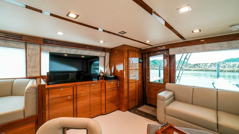Free Spool Yacht Photos Pics Luxurious interior of 2023 Viking 72 yacht with modern furnishings and large TV.