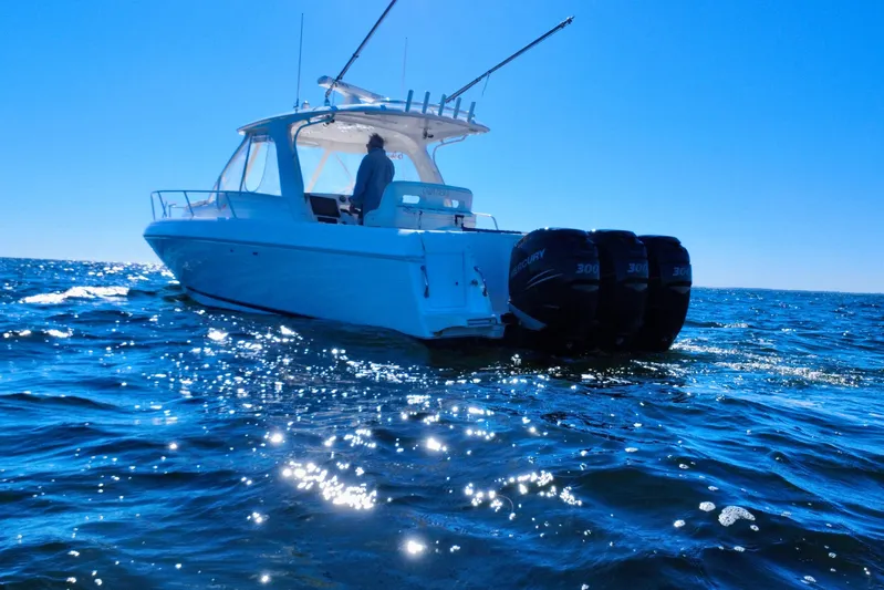  Yacht Photos Pics 2000 Intrepid 377 Walkaround boat on open water with triple Mercury engines.