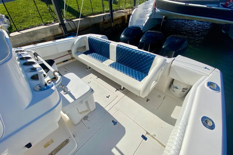  Yacht Photos Pics 2000 Intrepid 377 Walkaround boat interior with blue and white seating, docked by the water.
