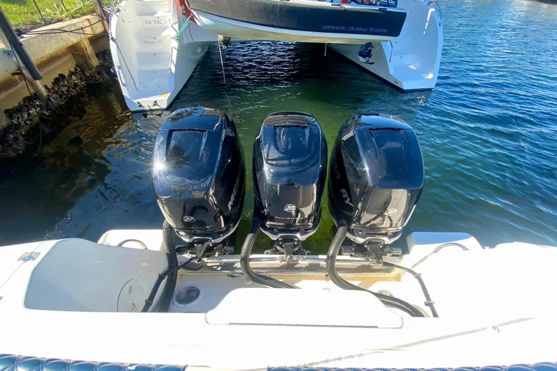 Yacht Photos Pics Triple Mercury outboard engines on a 2000 Intrepid 377 Walkaround boat, docked in clear water.