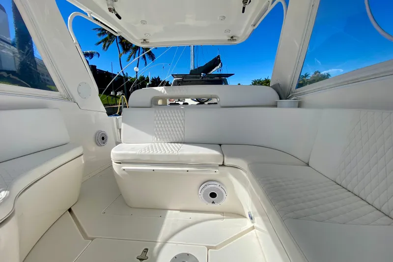  Yacht Photos Pics Luxurious interior of 2000 Intrepid 377 Walkaround boat with white seating and blue sky.