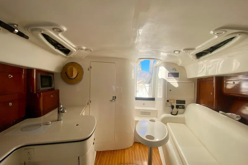  Yacht Photos Pics Interior of 2000 Intrepid 377 Walkaround boat with white seating and wooden accents.