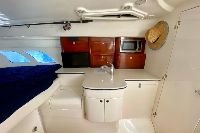  Yacht Photos Pics Interior of 2000 Intrepid 377 Walkaround with kitchenette, microwave, and cozy sleeping area.
