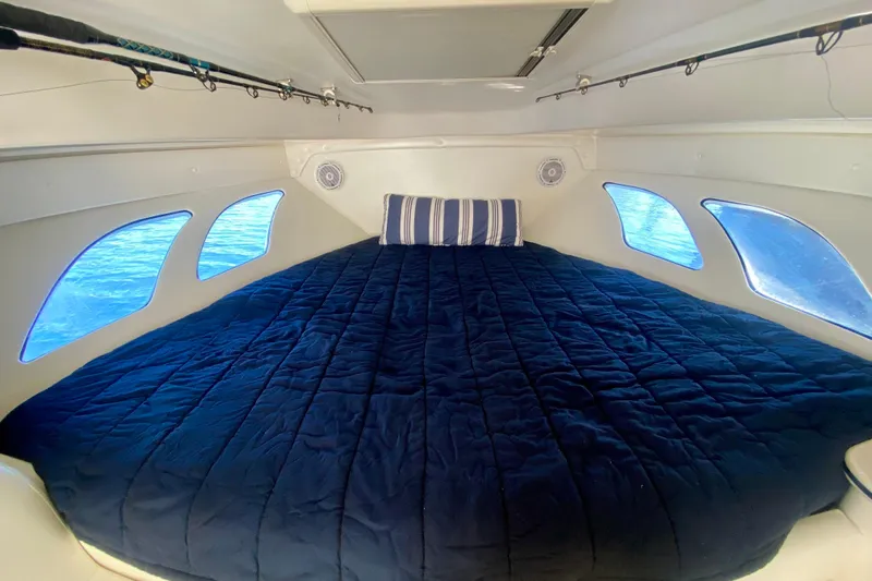  Yacht Photos Pics Cozy cabin interior of 2000 Intrepid 377 Walkaround with blue bedding and windows.