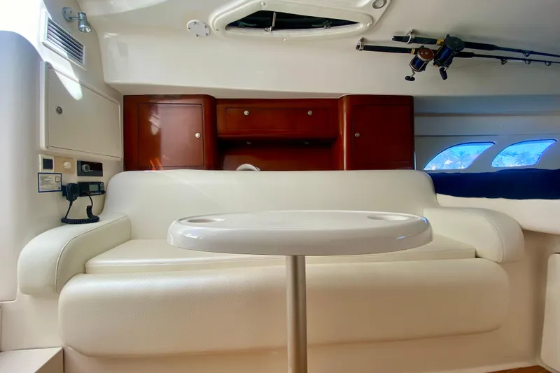  Yacht Photos Pics Interior of a 2000 Intrepid 377 Walkaround boat with white seating and wooden cabinets.