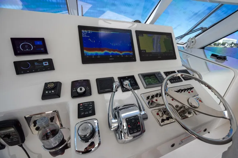 True Story Yacht Photos Pics Control panel of 2012 Cabo 40 Hardtop Express yacht with navigation screens and steering wheel.