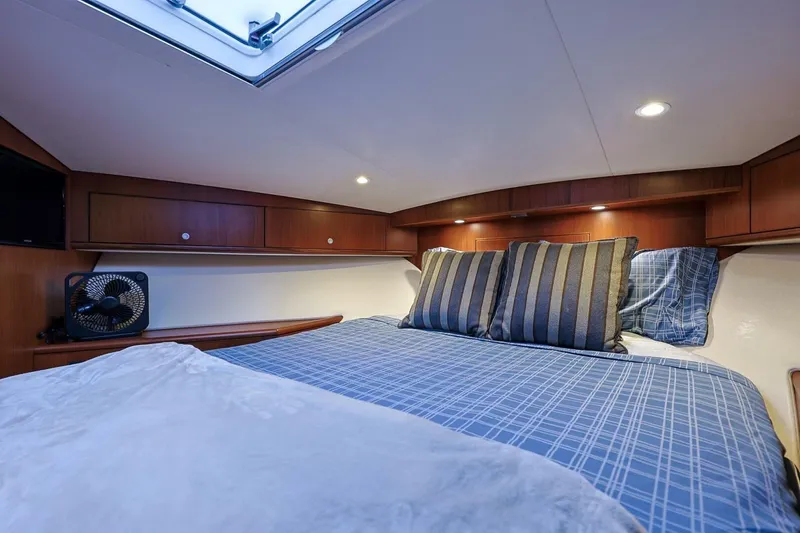 True Story Yacht Photos Pics Luxurious cabin interior of 2012 Cabo 40 Hardtop Express with cozy bedding and ambient lighting.