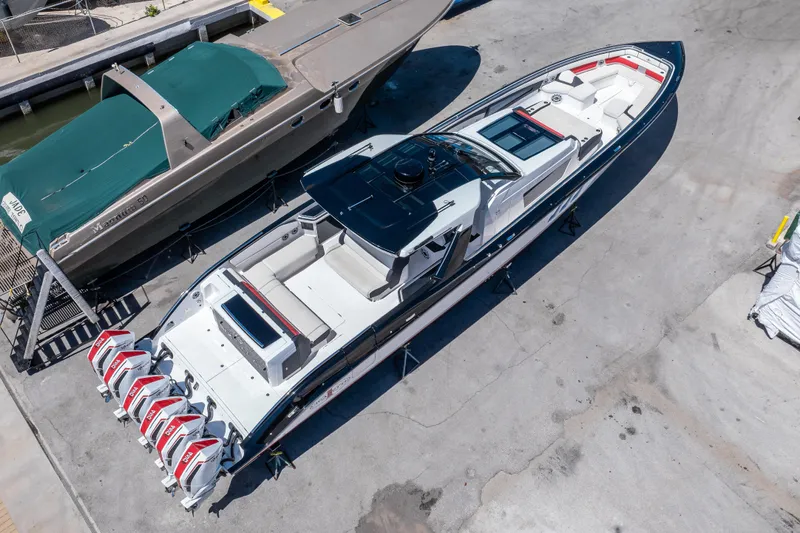  Yacht Photos Pics 2021 Cigarette 59 Tirranna boat with multiple engines, docked on a concrete surface.