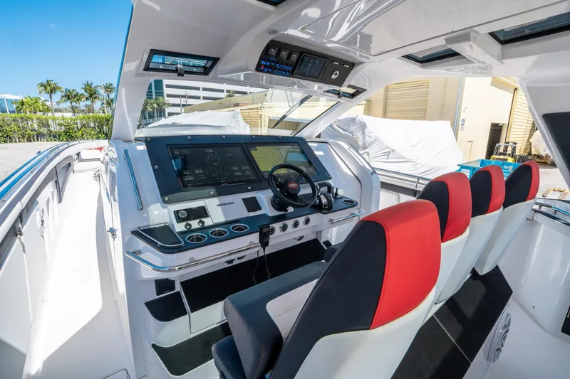  Yacht Photos Pics 2021 Cigarette 59 Tirranna boat cockpit with modern controls and red-accented seating.