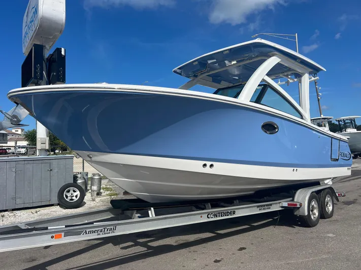  Yacht Photos Pics 2025 Robalo R257 Dual Console boat on trailer, blue hull, sunny day.