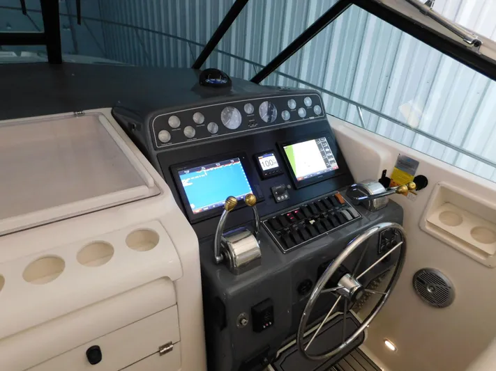 Sun Baked Yacht Photos Pics 1999 Tiara Yachts 3500 Express helm with navigation screens and steering wheel.